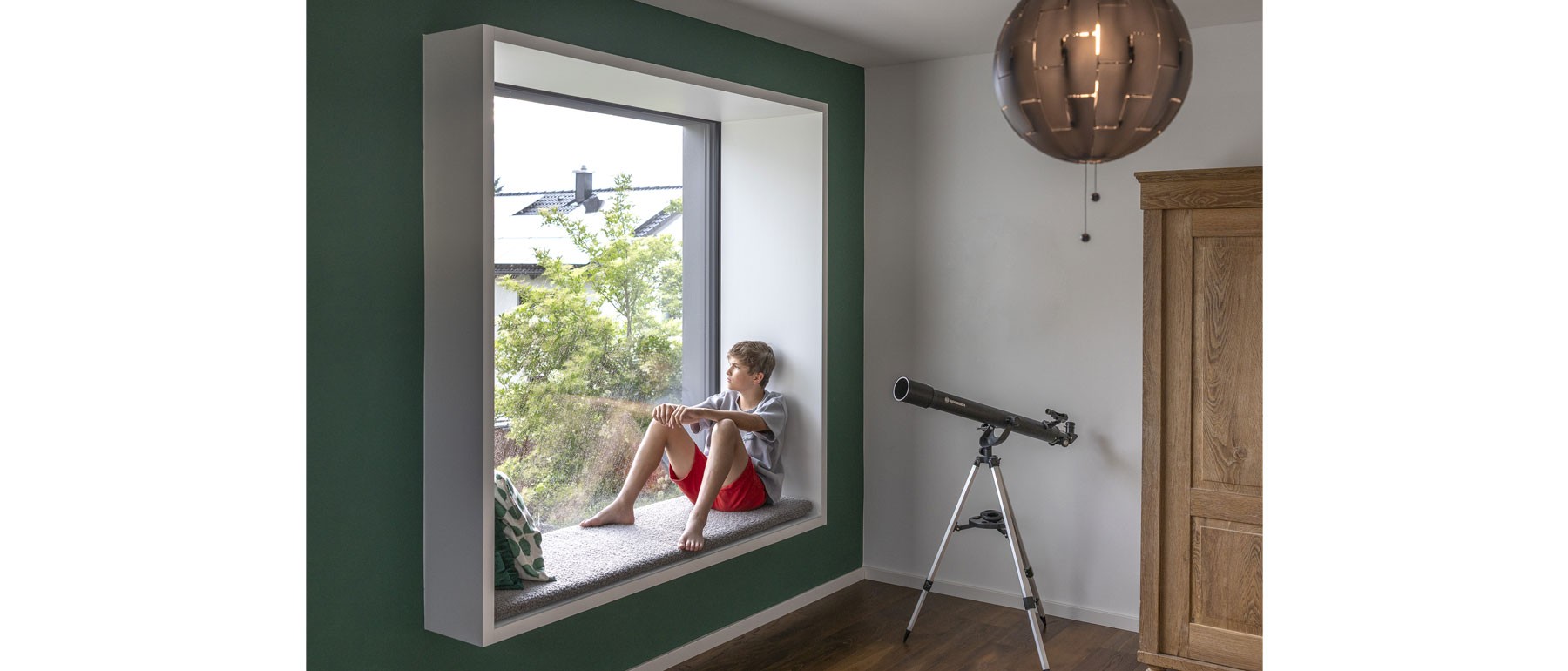 Raumhohe Tür im modernen Holzhaus mit Blick auf den zentralen Innenhof 